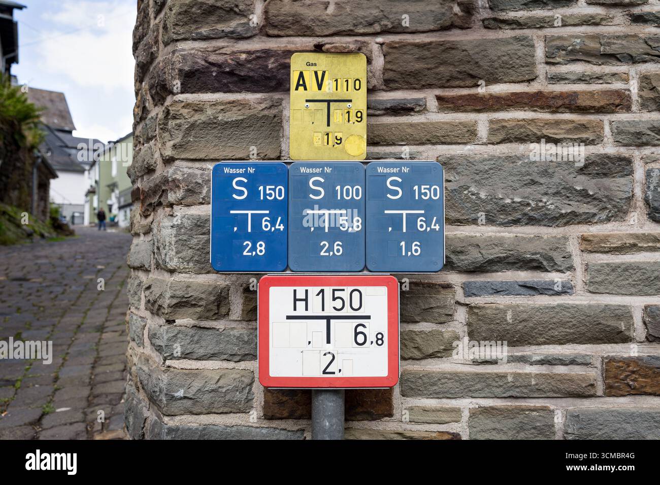 Panneaux de localisation des services publics (système de services publics) pour l'eau, le gaz et la bouche d'incendie sur un mur de pierre, Allemagne Banque D'Images