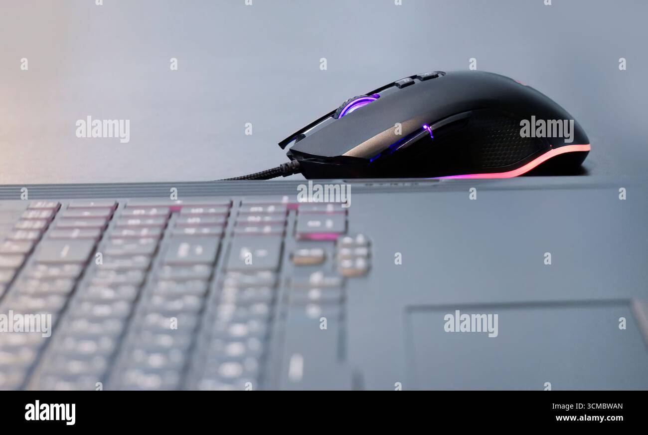 Une souris de jeu illuminée, lumières LED, lumières colorées, souris filaire, gadget numérique, fun Time, e sport, concept de souris de jeu, E Sport commercial Banque D'Images