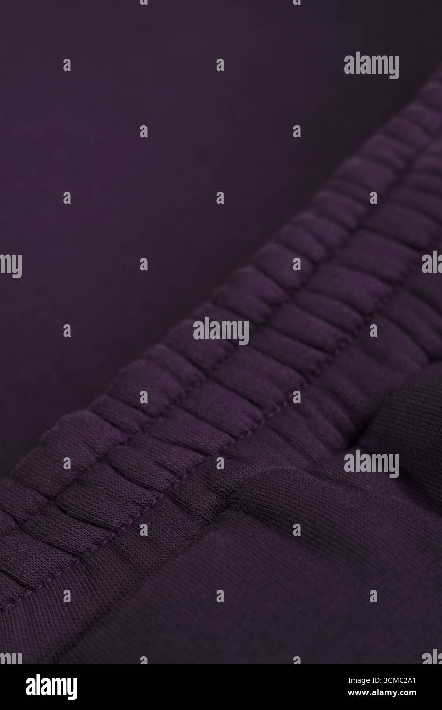 Survêtement violet foncé chaud. Gros plan de la ceinture élastique. Textile chaud tissu macro. Coton. Banque D'Images