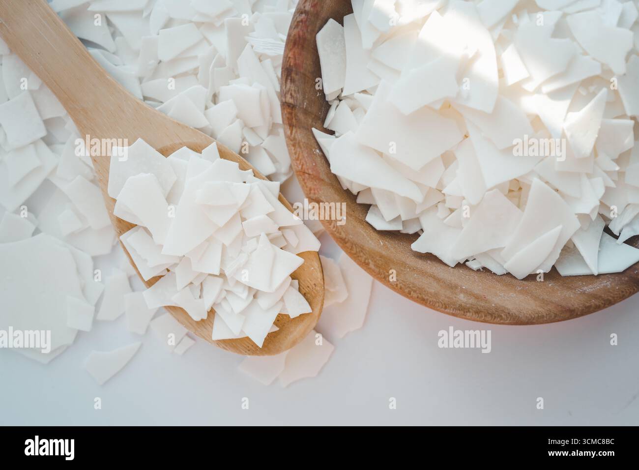 Cire de soja sur une cuillère en bois. Naturel, écologique, renouvelable, végétalien. Cire de bougie de soja. Banque D'Images