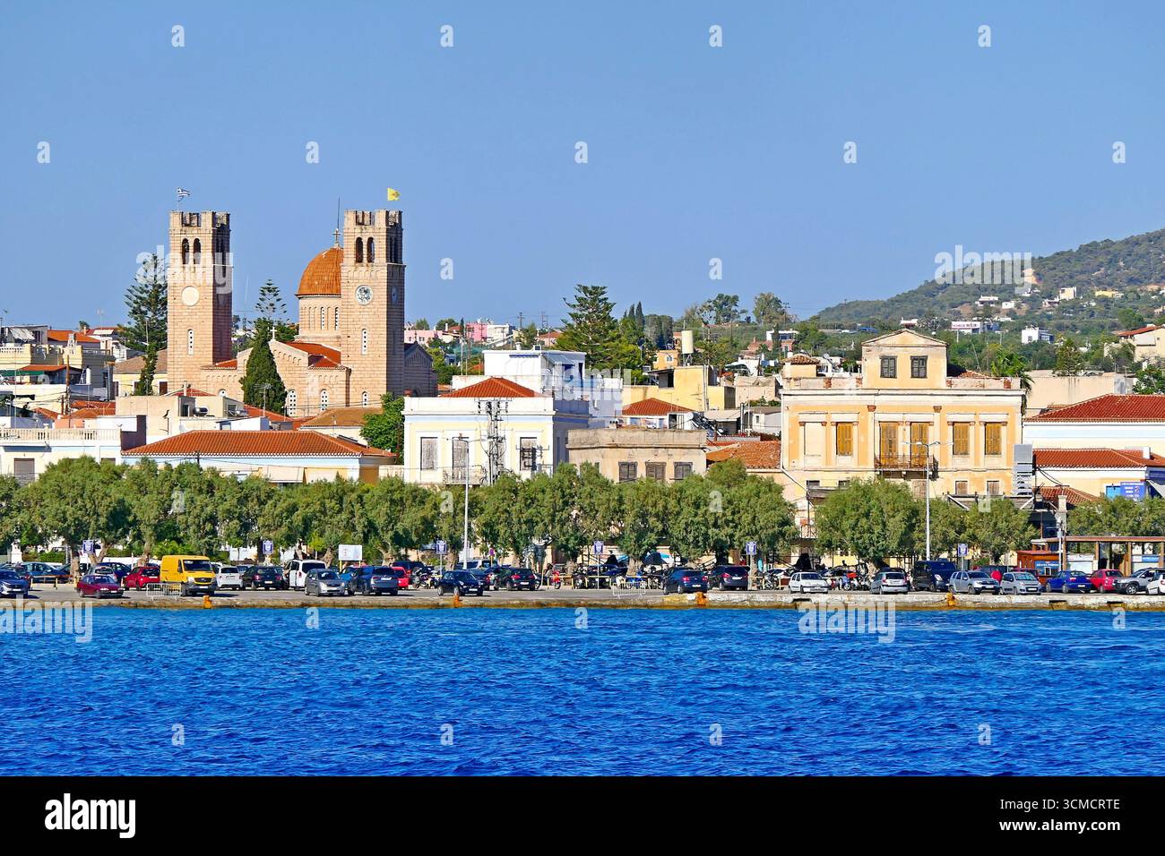 Vue panoramique depuis un bateau de croisière sur la côte de l'île d'Egine avec l'impressionnante église de style byzantin d'Agios Nikolaos, Grèce Banque D'Images