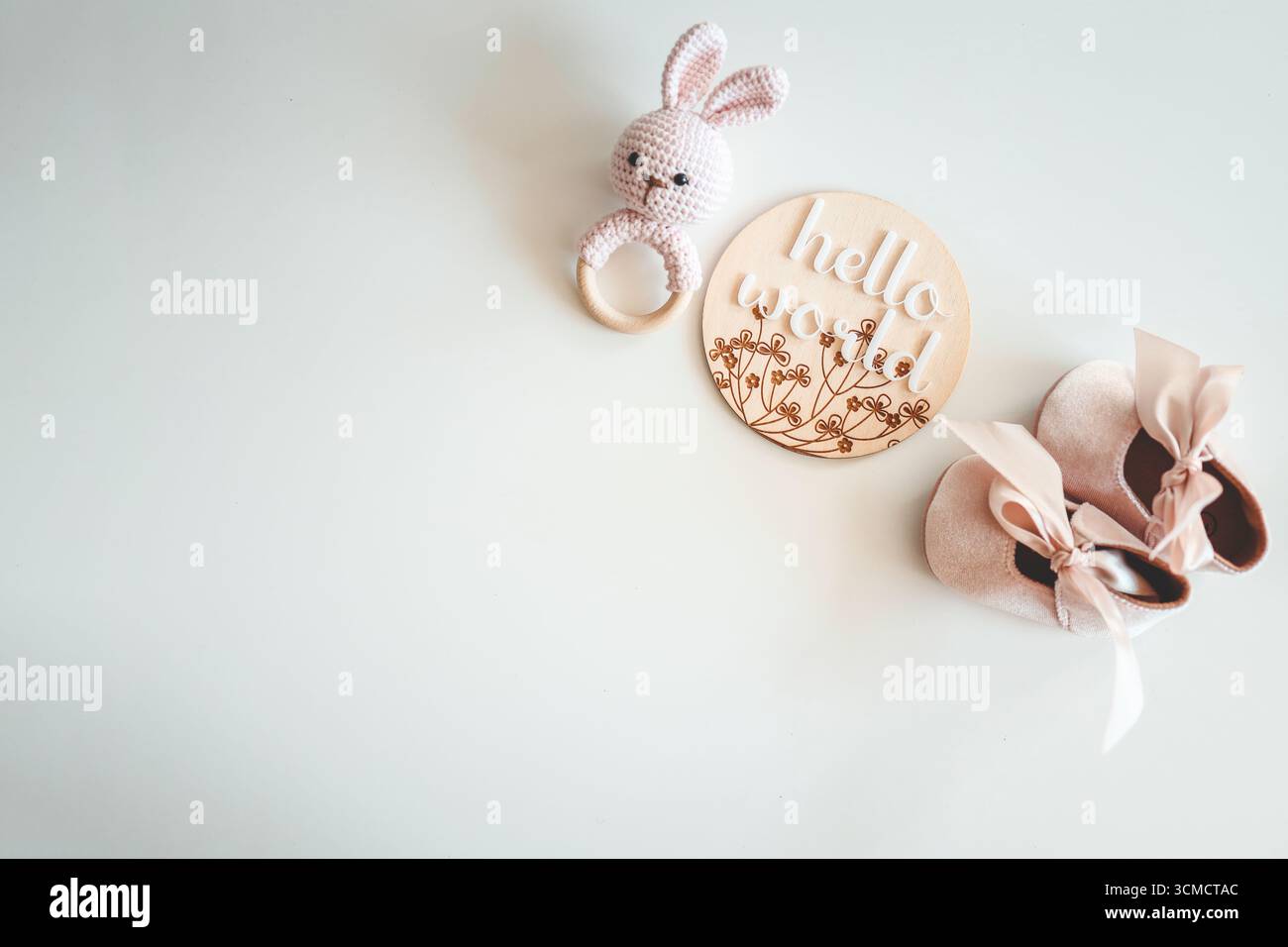 Hochet tricoté à la main et pantoufles rose bébé. Banque D'Images