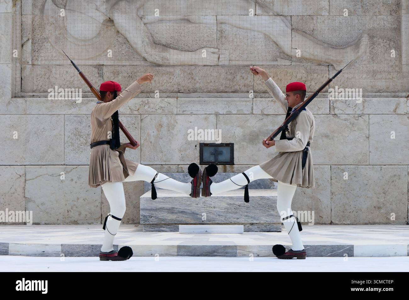 Pose synchronisée de deux beaux gardes de la Garde d'honneur de la Garde présidentielle sur la tombe du soldat inconnu à Athènes, Grèce Banque D'Images
