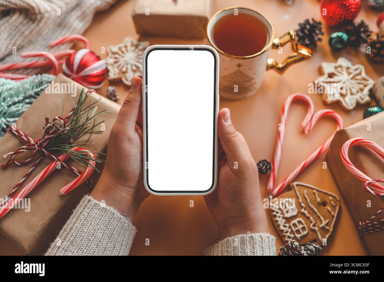 Téléphone avec écran isolé sur fond de cadeaux de Noël. Banque D'Images Téléphone avec écran isolé sur fond de cadeaux de Noël. Banque D'Images