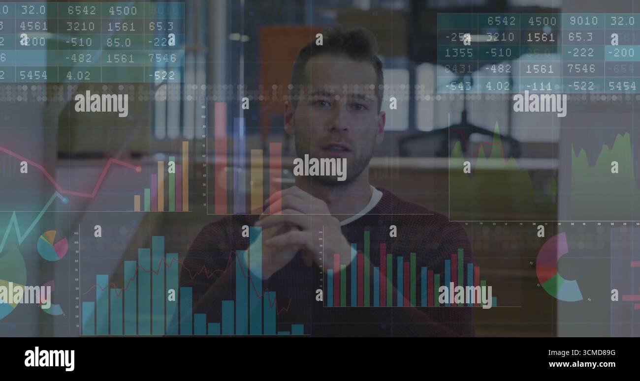 Analyste de bureau masculin portant un pull marron analysant des tableaux de données et des graphiques financiers dans le bureau Banque D'Images