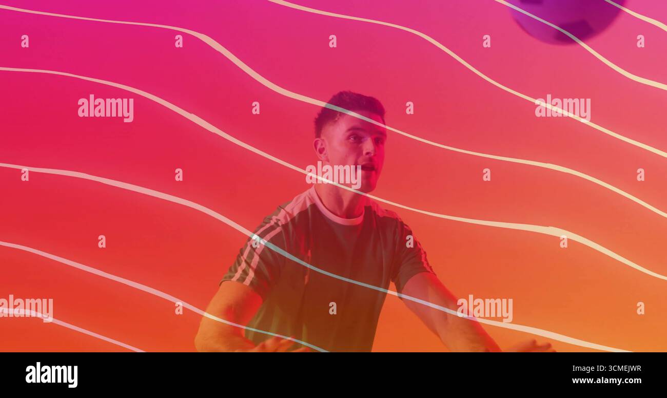 Pédaler amateur masculin portant une chemise de sport verte sur vélo stationnaire en studio, avec des stries de néon Banque D'Images