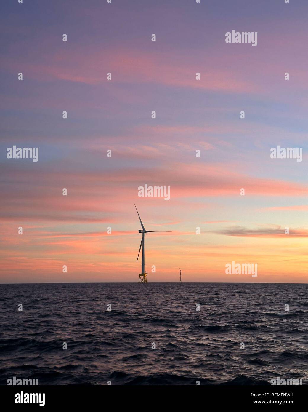 Éolienne offshore en mer du Nord au coucher du soleil, infrastructure d'énergie renouvelable avec océan calme et ciel nocturne coloré. Banque D'Images Éolienne offshore en mer du Nord au coucher du soleil, infrastructure d'énergie renouvelable avec océan calme et ciel nocturne coloré. Banque D'Images