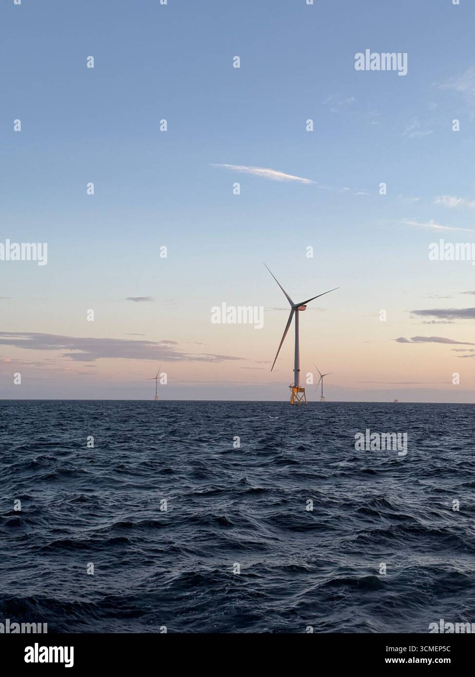 Éolienne offshore en mer du Nord au crépuscule, infrastructure d'énergie renouvelable avec mer calme et lumière douce du soir. Banque D'Images Éolienne offshore en mer du Nord au crépuscule, infrastructure d'énergie renouvelable avec mer calme et lumière douce du soir. Banque D'Images