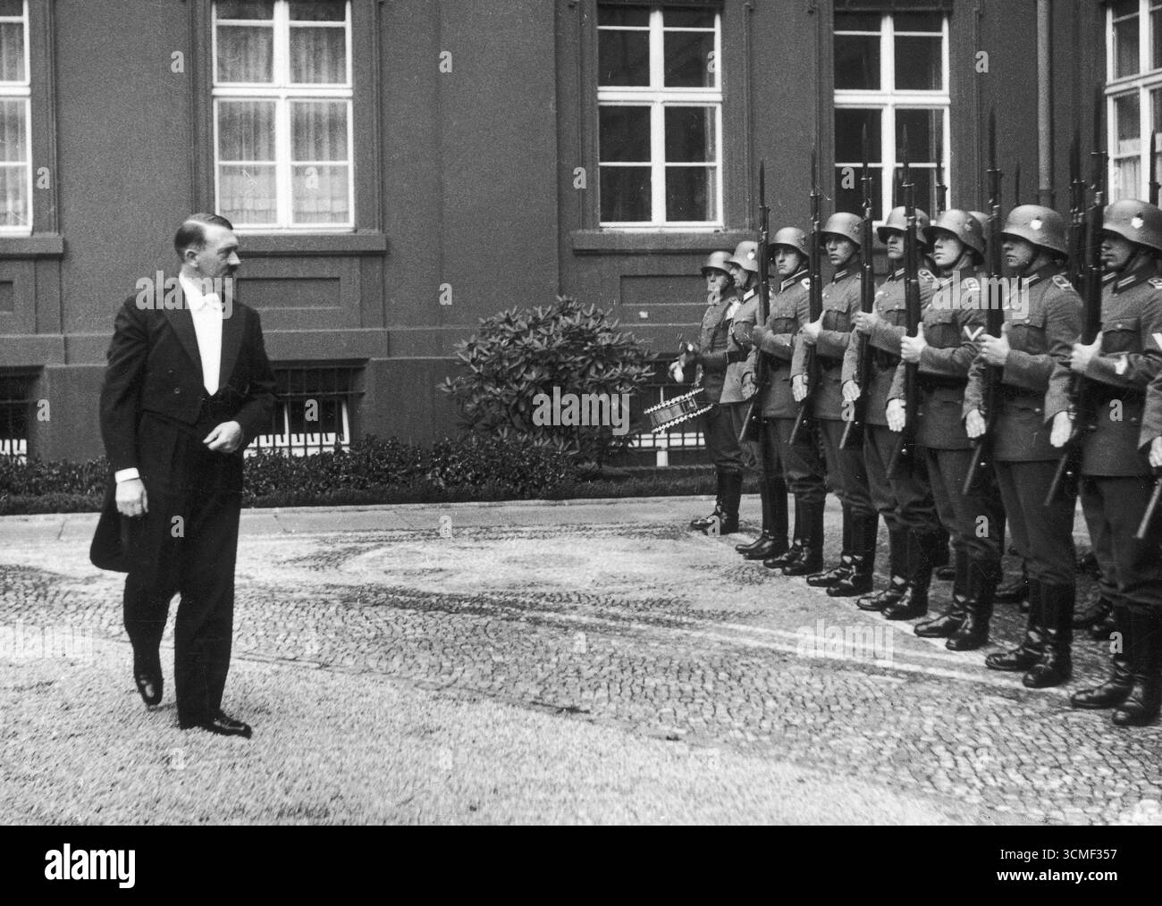 Le chancelier du Reich Adolf Hitler en smoking, en route pour une réunion avec des diplomates, passe devant la garde d'honneur, 1934 Banque D'Images