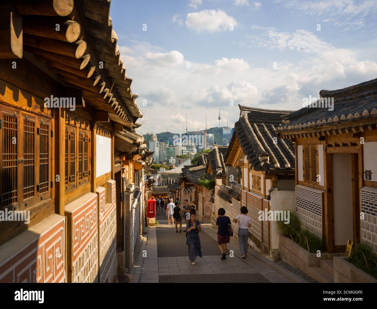 Bukchon Hanok Village est un quartier résidentiel dans le district de Jongno, Séoul, Corée du Sud vue sur la rue au coucher du soleil avec vue sur Séoul Banque D'Images