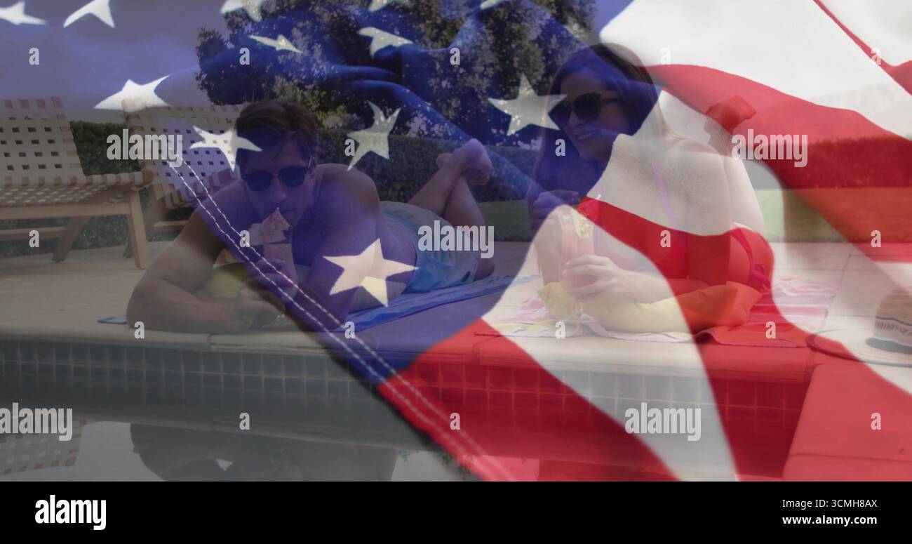 Couple de repos portant des maillots de bain couchés sur des serviettes à la maison au bord de la piscine, avec recouvrement de drapeau de tasse en plastique Banque D'Images