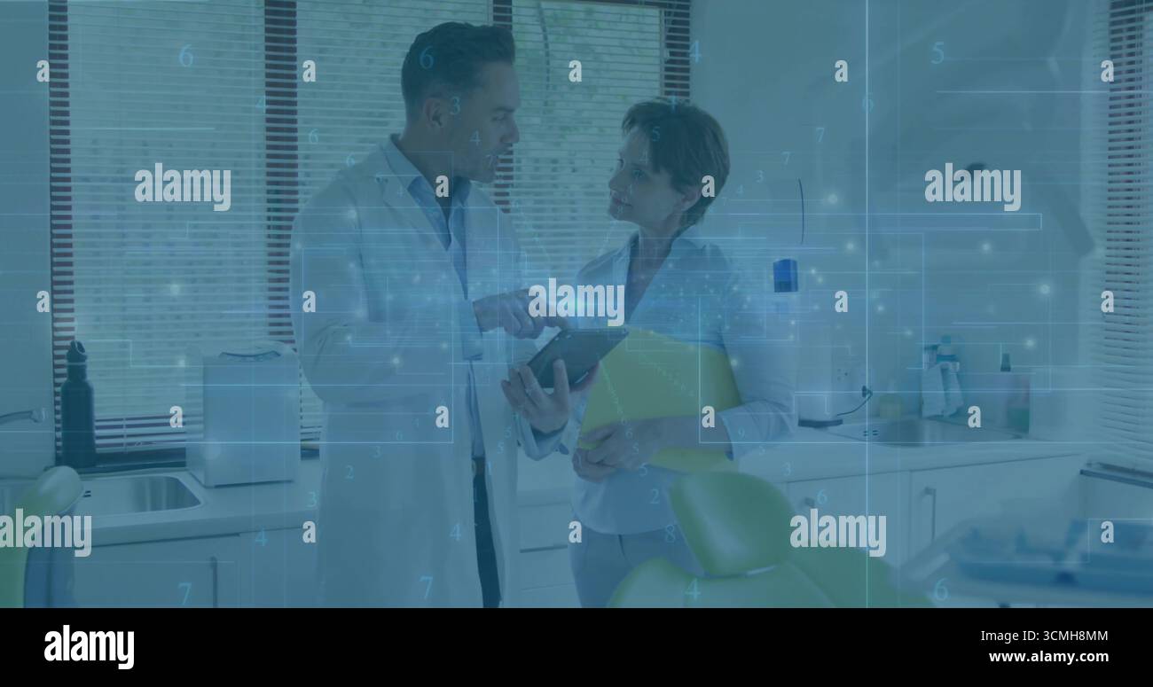 Dentiste debout et assistant examinant tablette et dossier au cabinet dentaire, avec superposition de réseau Banque D'Images