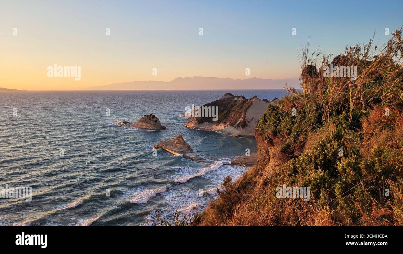 Une vue aérienne rêveuse et rosée des falaises d'argile emblématiques du cap Drastis au coucher du soleil sur l'île de Corfou, en Grèce Banque D'Images