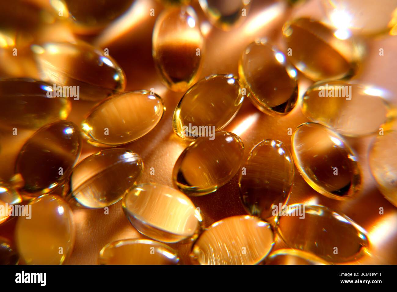 De nombreuses pilules de vitamine dorée créent un motif, représentant la santé et le bien-être Banque D'Images