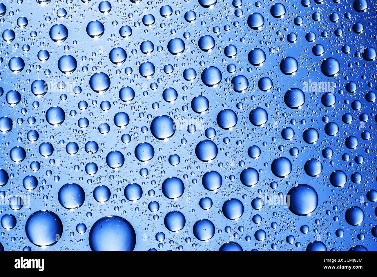 Texture des gouttes d'eau sur la surface bleue. Fond abstrait avec des bulles liquides. Concept d'hydratation fraîche et d'humidité. Macrophotographie aqua naturelle. Banque D'Images