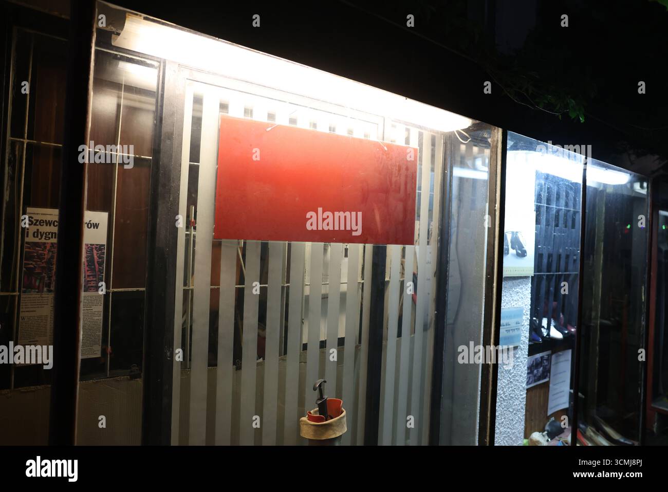 Vue nocturne d'une vitrine affichant un panneau rouge vierge, idéal pour la publicité. Banque D'Images