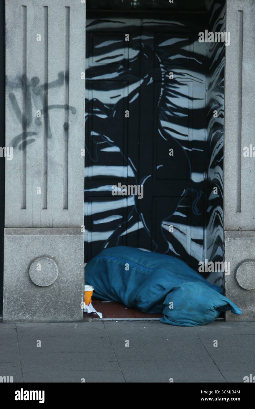 Dublin, Irlande - 16 septembre 2025 - Un sans-abri dans un sac de couchage dort dur dans une porte le long des quais dans le centre-ville de Dublin par un matin sec dans la capitale irlandaise Banque D'Images