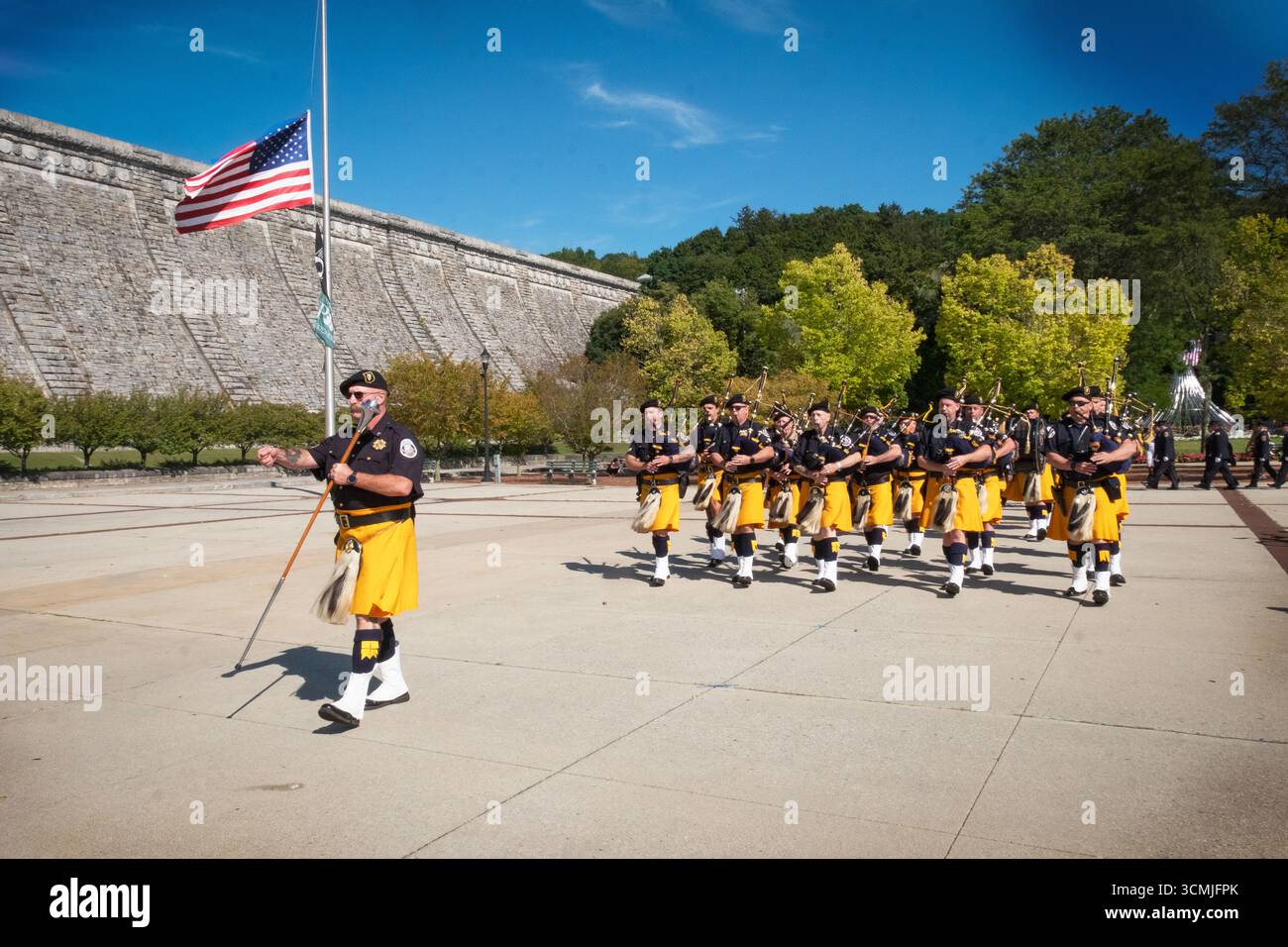 Les tuyaux et les tambours de la police Emerald Society of Westchester défilent avant le chant de l'hymne national lors de la cérémonie commémorative du 11 septembre. Banque D'Images