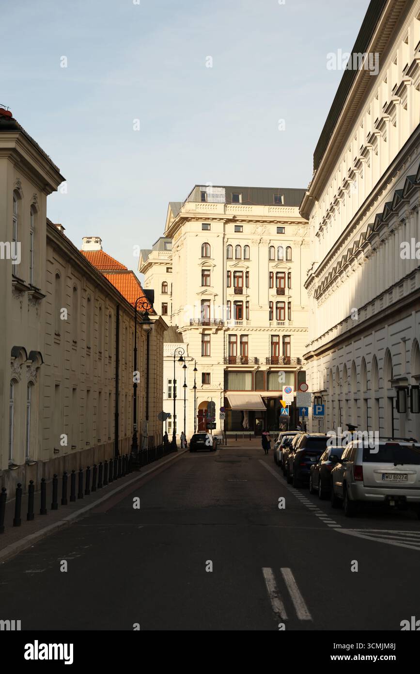 Allée urbaine ensoleillée avec façades classiques et longue perspective pour les annonces lifestyle Banque D'Images