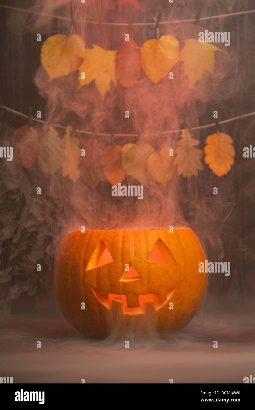 Lanterne luisante entourée de feuilles d'automne vibrantes et de brume, rehaussant l'esprit d'Halloween avec une atmosphère chaleureuse et accueillante et un cha de saison Banque D'Images