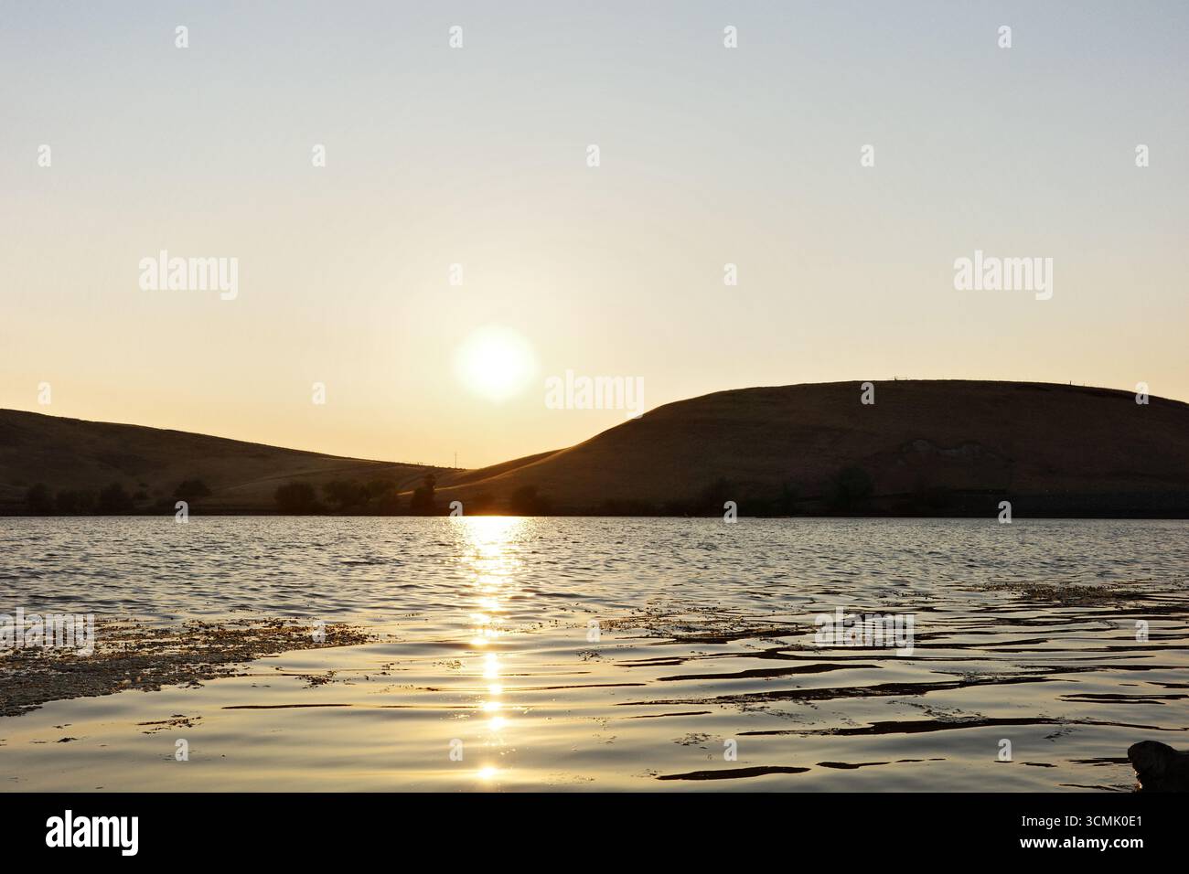 Coucher de soleil sur le réservoir Contra Loma à Antioch, Californie, qui fait partie du quartier du parc régional d'East Bay. La lumière dorée se reflète sur l'eau. Banque D'Images