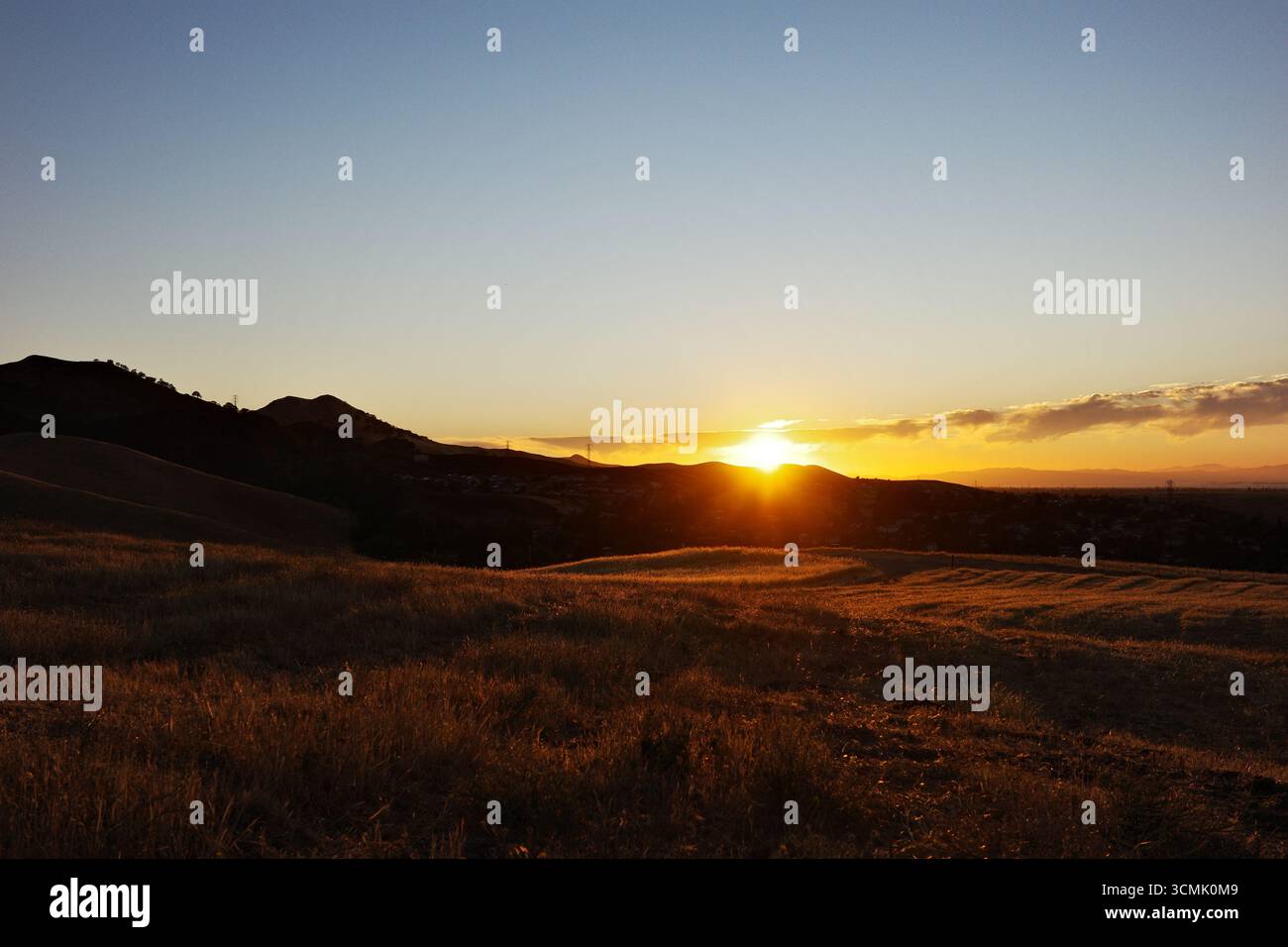 Cieux de coucher de soleil enflammé et crépuscule sur les collines de Contra Loma à Antioch, Californie. Le paysage d'East Bay est capturé dans des couleurs vives Banque D'Images