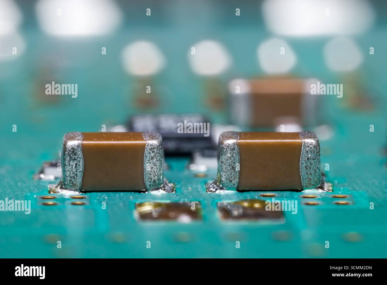 Vue rapprochée des dispositifs marron montés en surface sur une carte de circuit imprimé électronique. Banque D'Images