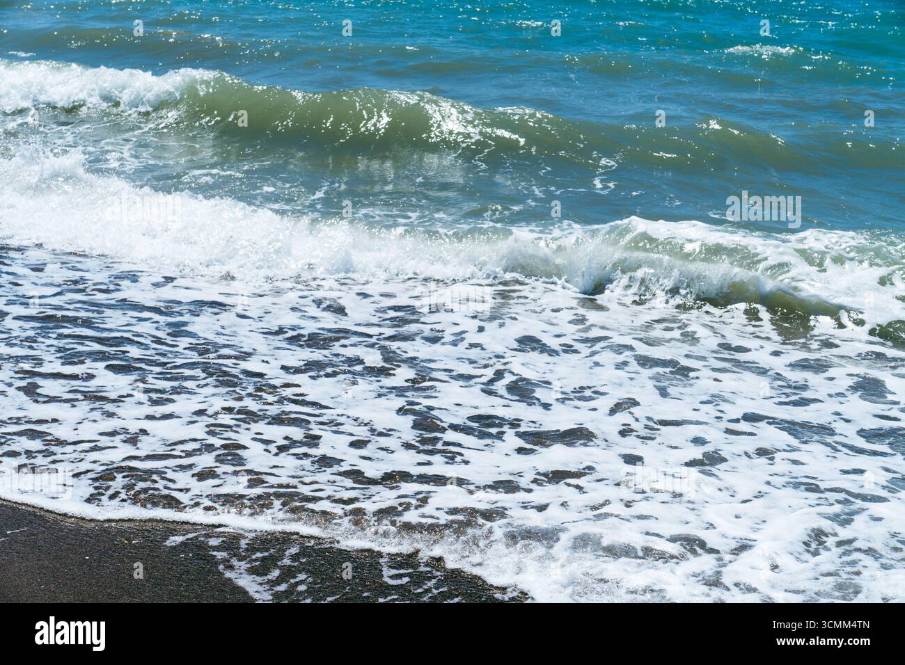 Mer bleue et grandes vagues et mousse. Tempête vague éclaboussant sur des galets en mer. Vagues de l'océan qui roulent. Fond de plage paradisiaque d'été. Puissantes vagues marines Banque D'Images