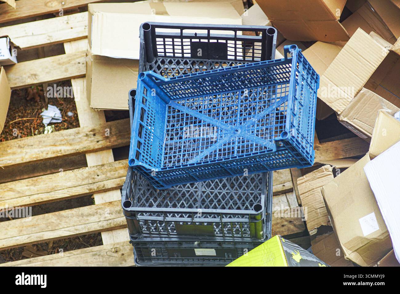 Vider les caisses en plastique et les palettes en bois. Déchets et matériaux de stockage. Concept d'emballage, logistique, défis de recyclage, culture de consommation mondiale Banque D'Images
