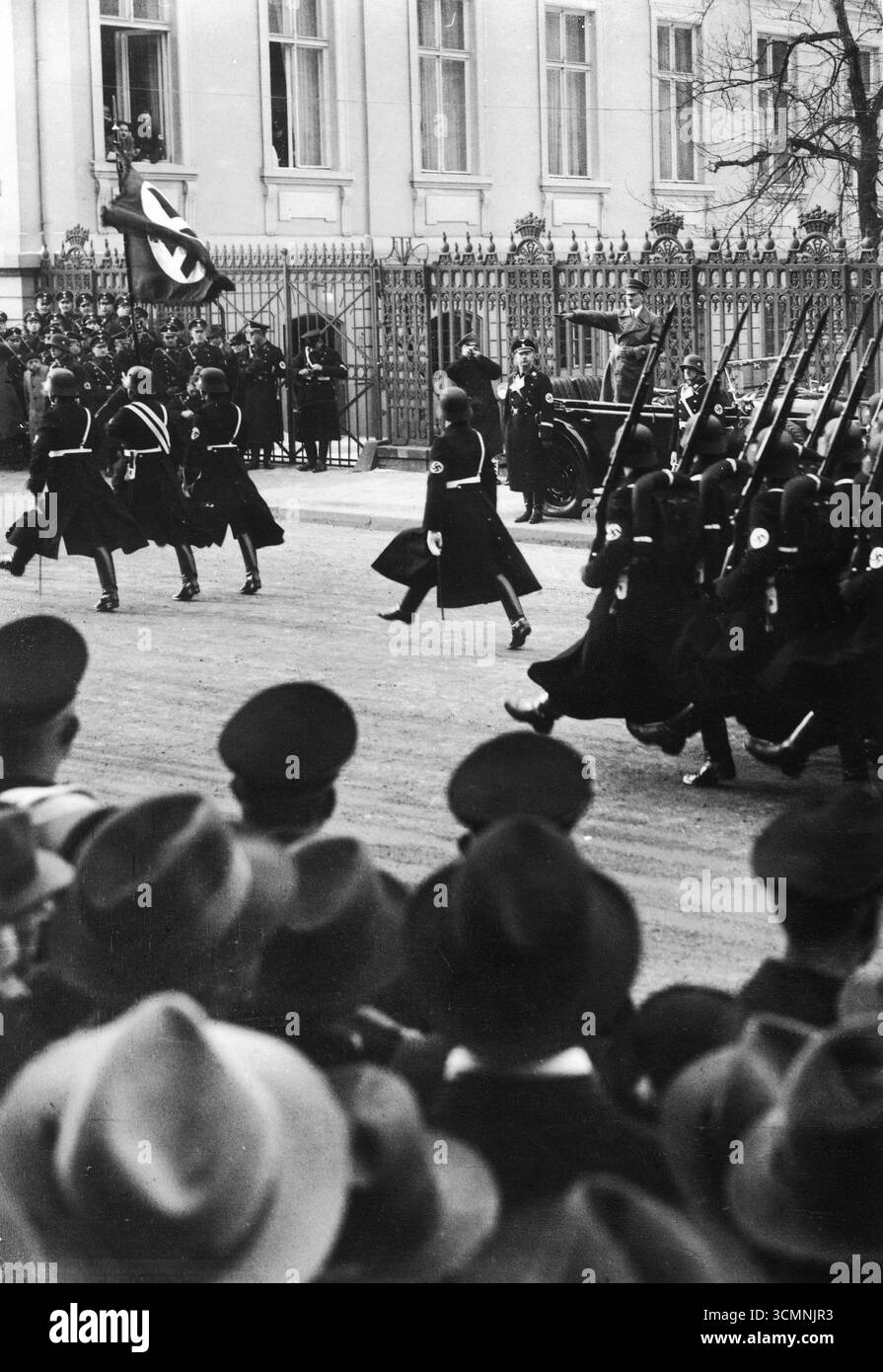 Le chancelier du Reich Adolf Hitler regarde un défilé militaire depuis sa voiture. Reichsfuehrer-SS Heinrich Himmler se tient sur le trottoir, 1937 Banque D'Images