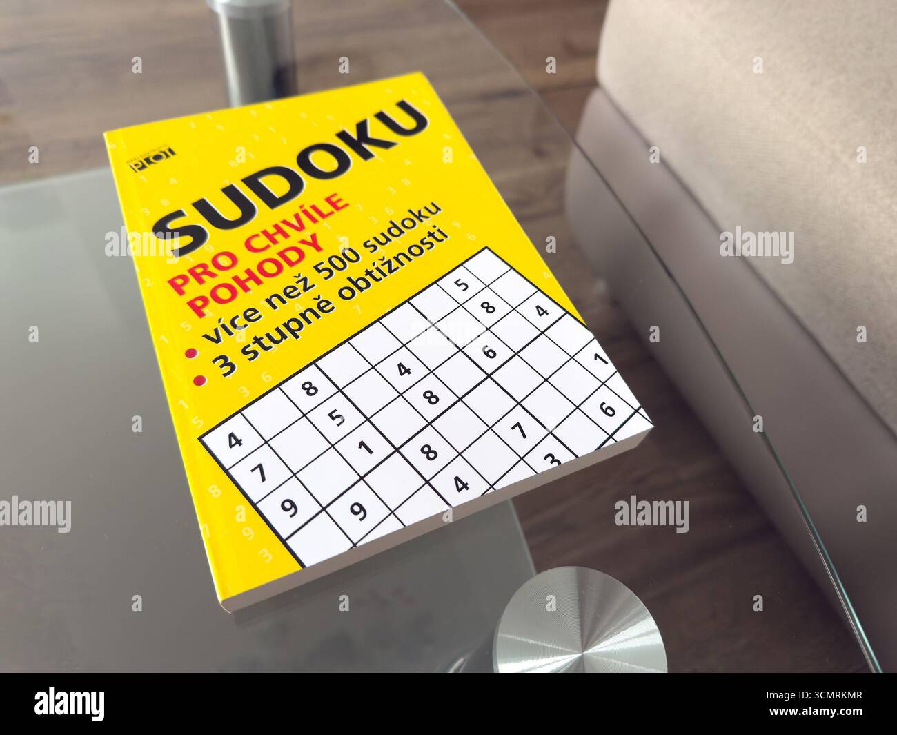 Ostrava, Tchéquie - 23 décembre 2024 : Livre avec mots croisés Sudoku et puzzle sur table en verre Banque D'Images