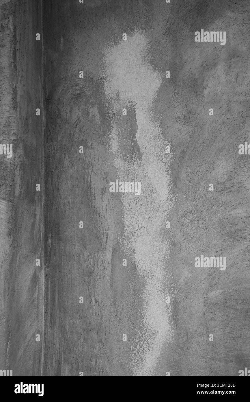 image grunge verticale abstraite noir et blanc d'un mur extérieur en béton ou en plâtre détérioré par les intempéries avec des formes et des motifs des couches grunge Banque D'Images