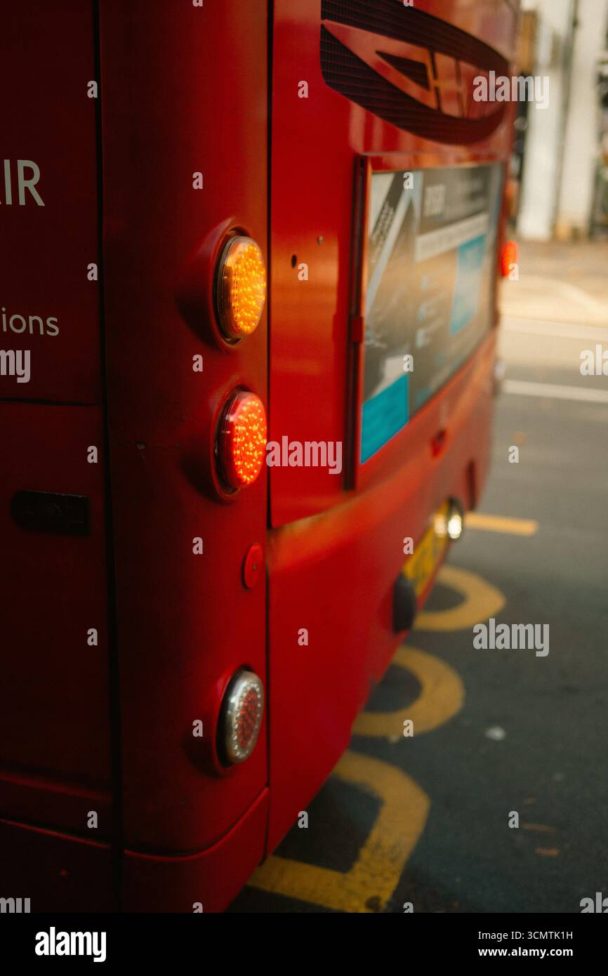 Twickenham, Londres, Royaume-Uni – 2025.09.06 – vue rapprochée des feux arrière éclairés sur un bus rouge classique de Londres, garé à un arrêt de bus avec des marquages de route vi Banque D'Images