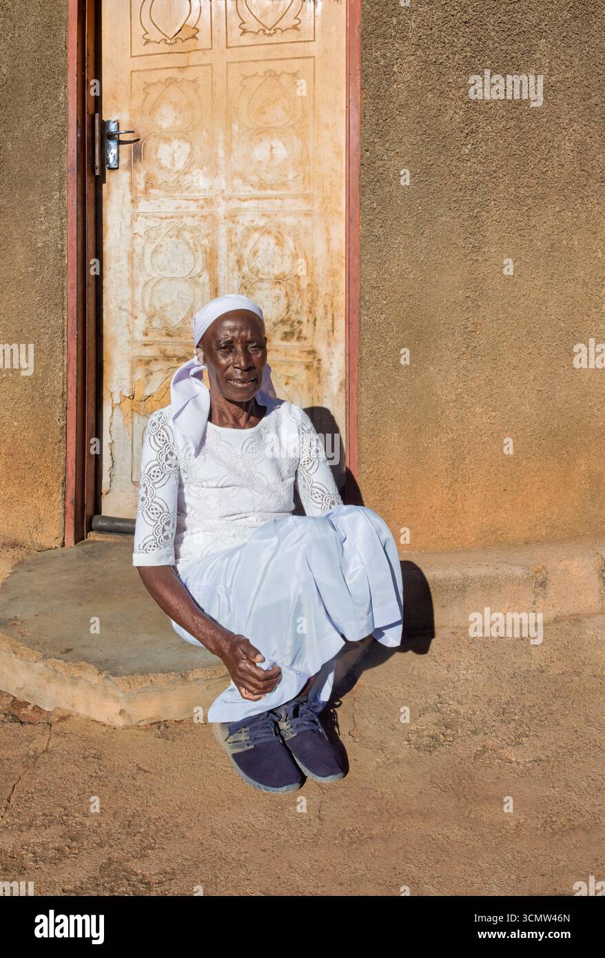 village célibataire zezuru vieille femme africaine portant un foulard assis devant la maison, dans la cour, portrait rapproché Banque D'Images