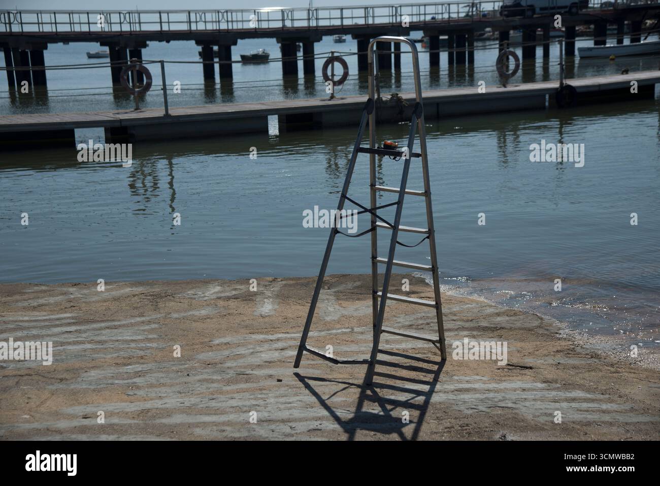Escalera de mano abierta sita en la rampa de acceso al Agua en la zona de talleres del puerto del Rompido, en zona dembarque y desembarque de Barcos Banque D'Images