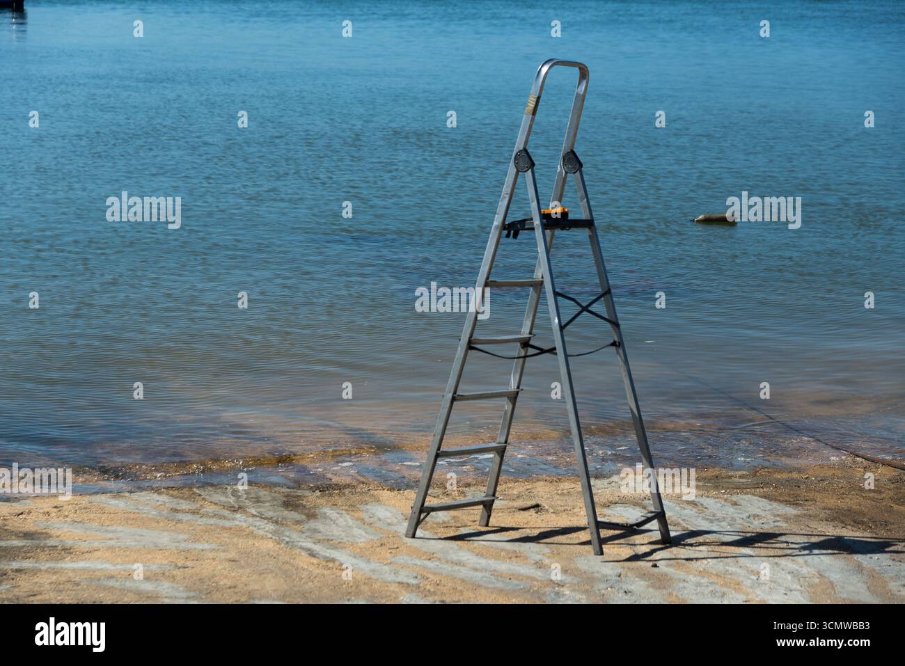 Escalera de mano abierta sita en la rampa de acceso al Agua en la zona de talleres del puerto del Rompido, en zona dembarque y desembarque de Barcos Banque D'Images