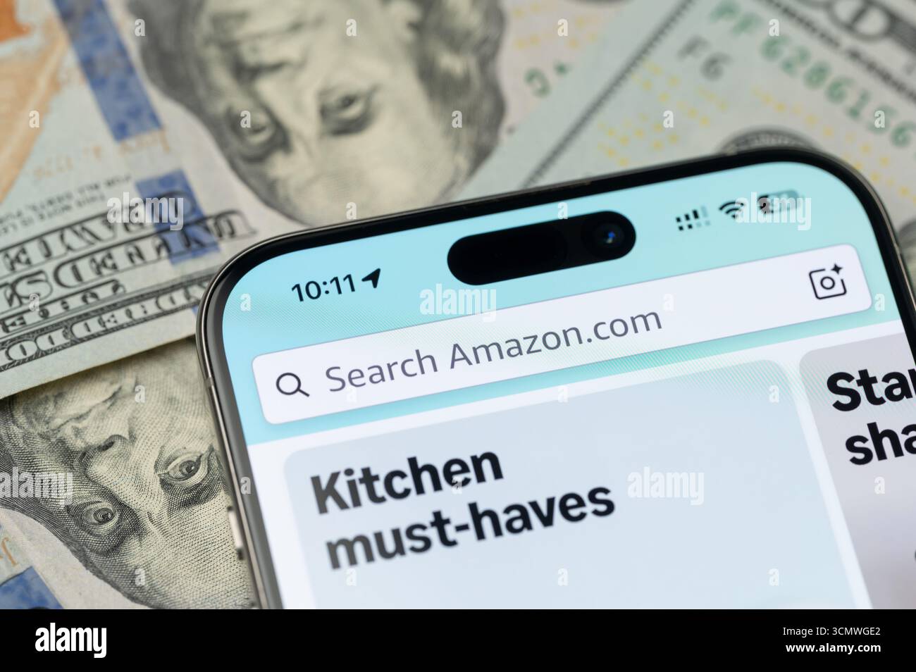 New York, États-Unis - 12 septembre 2025 : recherche pour acheter sur amazon boutique sur l'écran de smartphone avec fond dollar vue rapprochée Banque D'Images