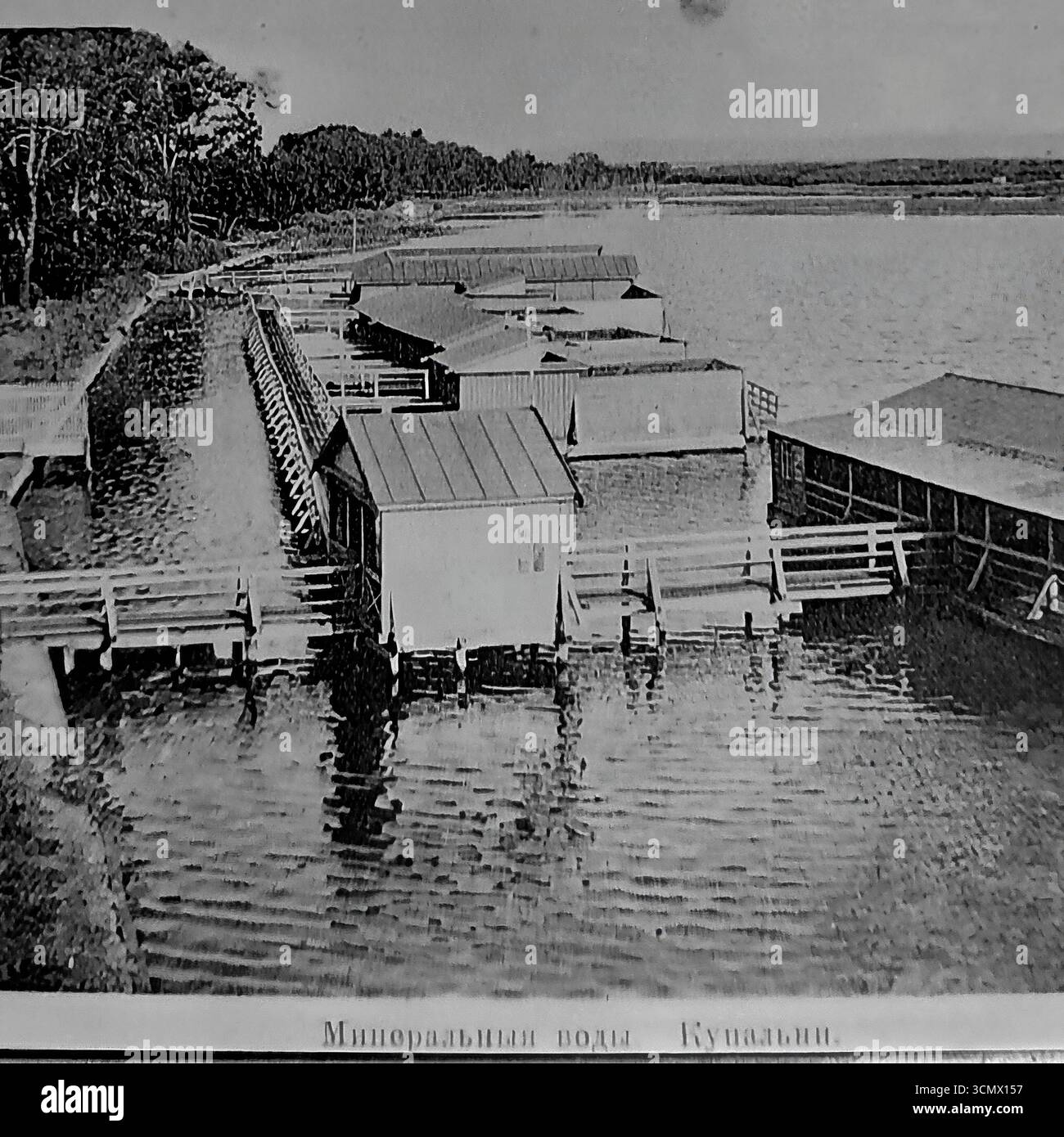 Une photographie historique des années 1900-1910, intitulée 'Mineralnye Vody. Kupalni.' (Eaux minérales. Maisons de bains.), montrant les maisons de bains thérapeutiques sur un lac salé au Slavyansk Resort dans l'Empire russe. Ces structures en bois sur pilotis avec cabines à langer étaient l’infrastructure de base de la balnéothérapie (cure d’eau), la principale méthode de traitement de la célèbre station thermale du Donbass Banque D'Images