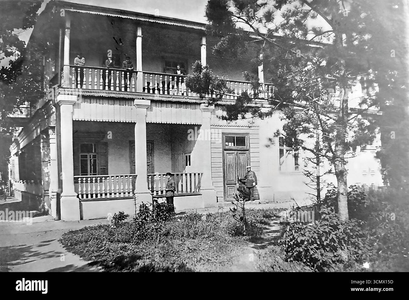 Une photographie historique des années 1900-1910, montrant l'une des datcha ou des villas d'hôtes du Slavyansk Resort dans l'Empire russe. Le bâtiment de deux étages avec des vérandas spacieuses, typique de l'architecture de la station balnéaire de l'époque, a été utilisé pour le logement confortable des vacanciers. La scène avec des gens en uniforme et sur le balcon transmet l'atmosphère d'une vie mesurée et de loisirs à la célèbre station de santé Donbass Banque D'Images