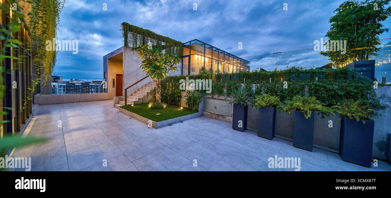 Terrasse sur le toit exclusive avec une végétation luxuriante, offrant un espace luxueux pour la détente en plein air et une vue sur la ville Banque D'Images