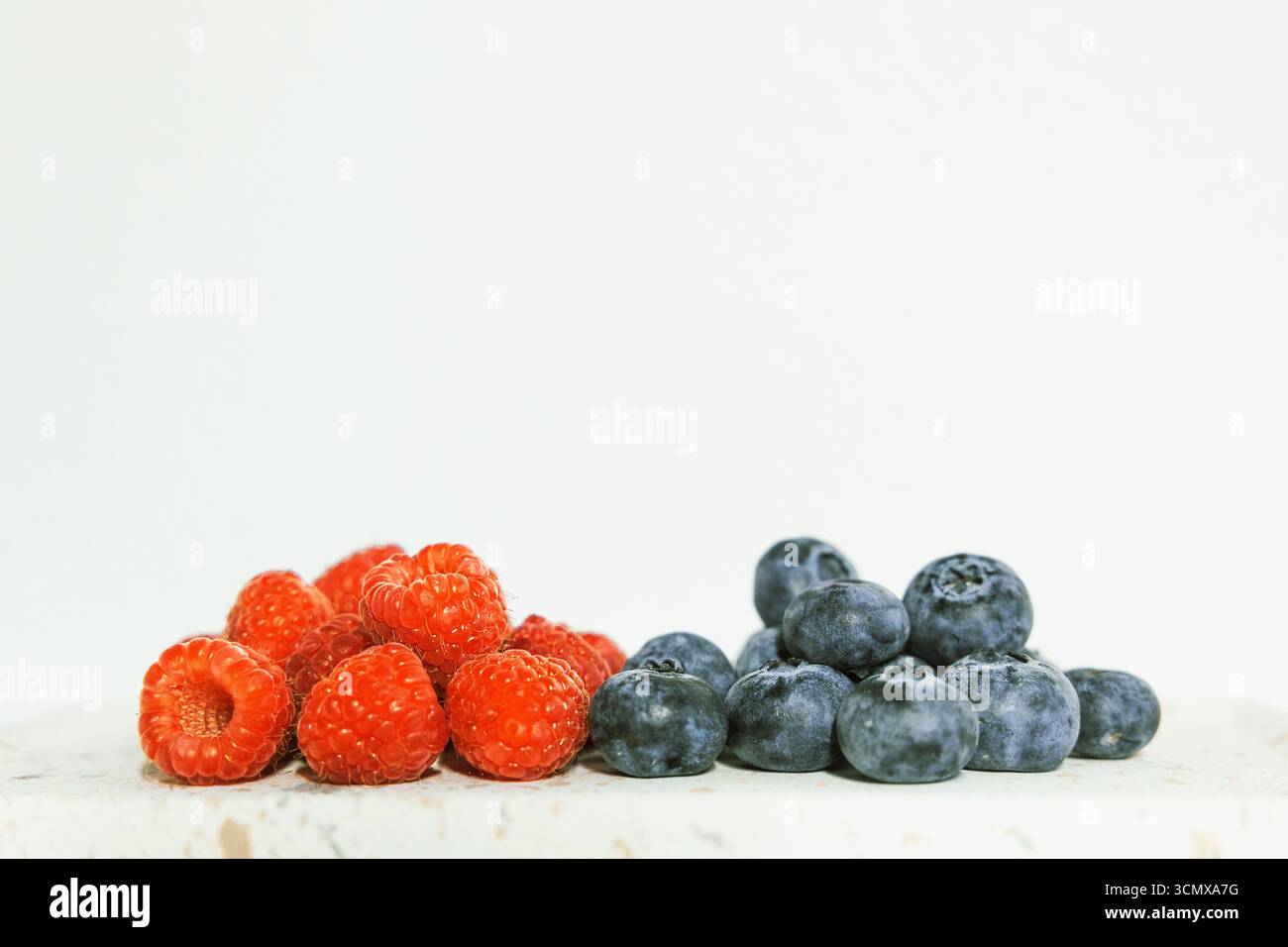 Les framboises et les bleuets sont un petit déjeuner ou un dessert nutritif coloré et sain. Un gros plan qui montre les détails juteux. Parfait pour un wallpape Banque D'Images