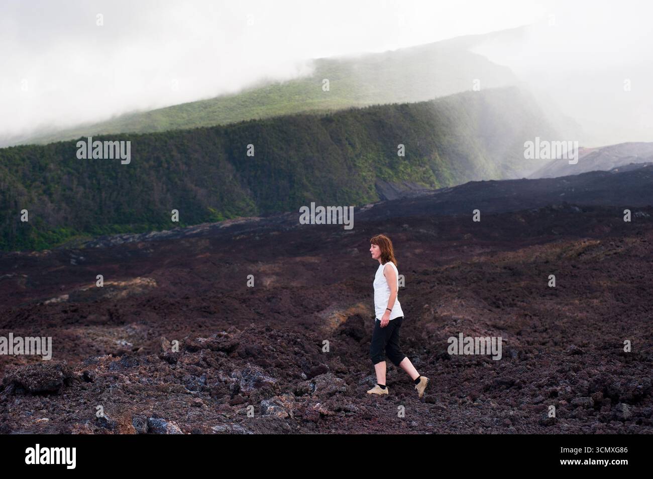 Femme marchant sur la coulée de lave froide, Côte du Grand Brule, Réunion Banque D'Images