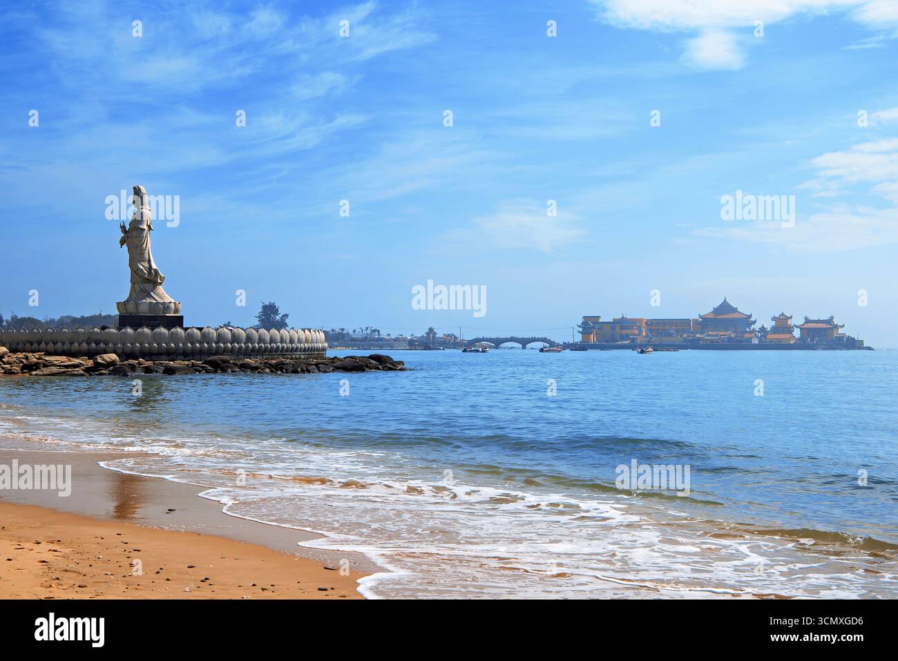 Statue majestueuse de Guanyin (Déesse de la Miséricorde) avec le temple Luojia dans la mer en arrière-plan, Côte d'Or, ville de Shishi, Fujian, Chine Banque D'Images