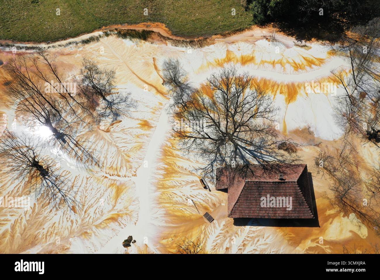 Vue aérienne de la maison de village en train de couler au milieu de l'étang de décantation de drainage de mine acide toxique. Geamana, Rosia Montana, Roumanie Banque D'Images