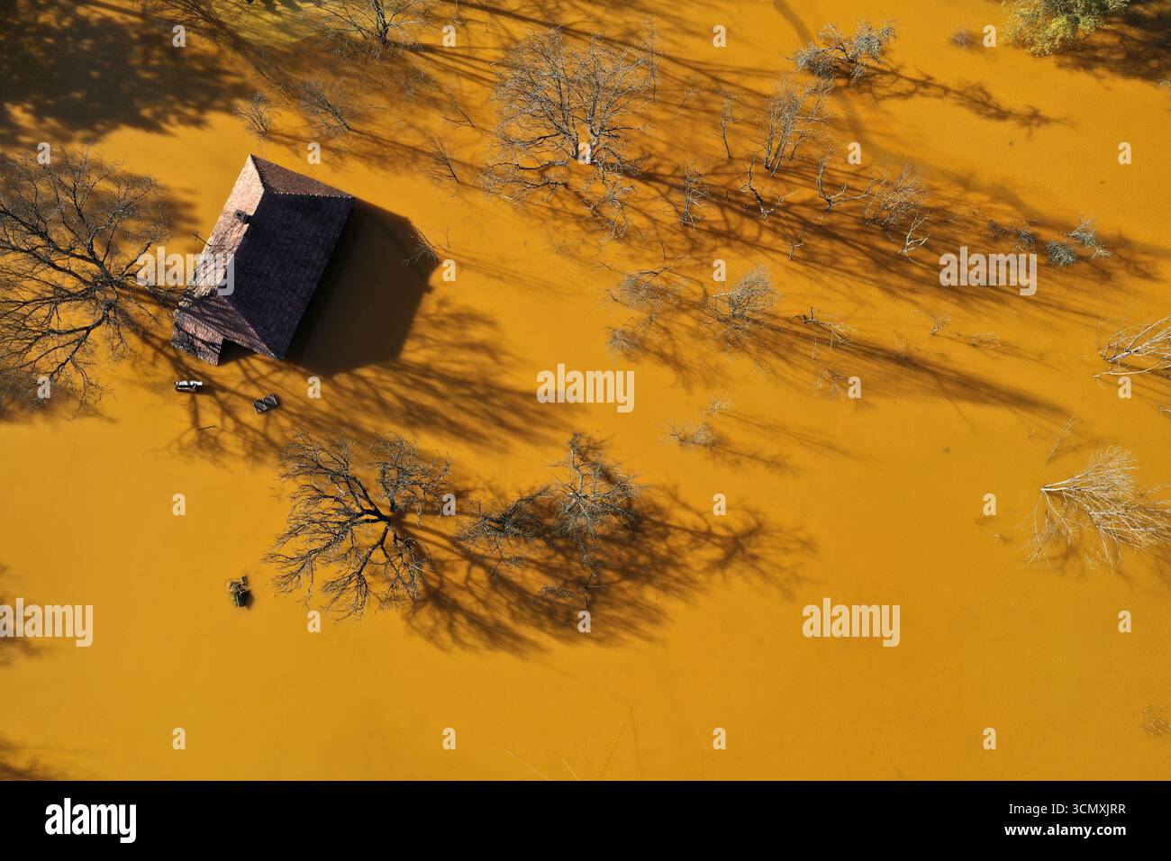 Vue aérienne de la maison de village en train de couler au milieu de l'étang de décantation de drainage de mine acide toxique. Geamana, Rosia Montana, Roumanie Banque D'Images