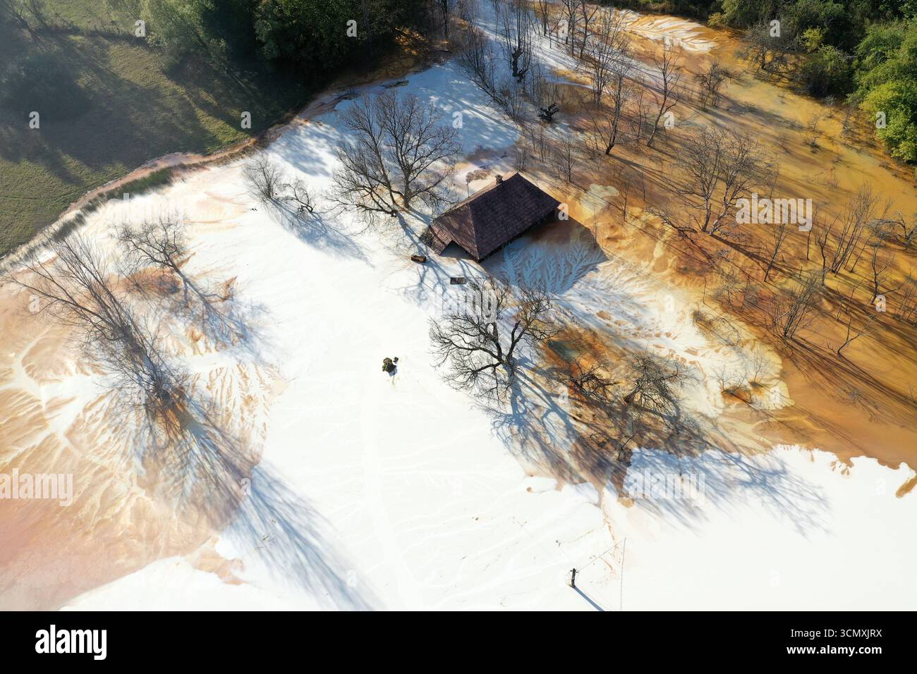 Vue aérienne de la maison de village en train de couler au milieu de l'étang de décantation de drainage de mine acide toxique. Geamana, Rosia Montana, Roumanie Banque D'Images