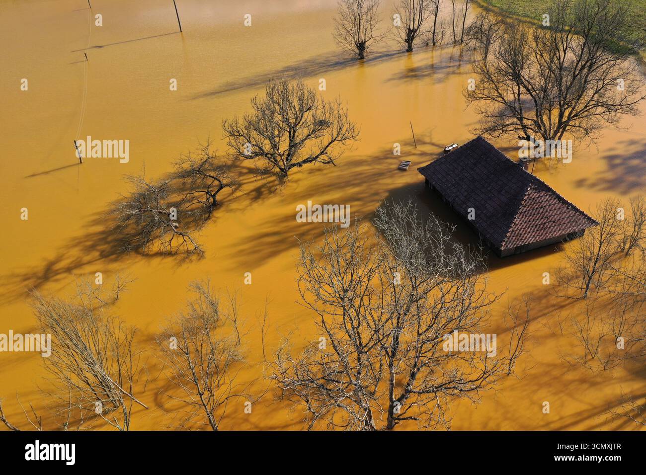 Vue aérienne de la maison de village en train de couler au milieu de l'étang de décantation de drainage de mine acide toxique. Geamana, Rosia Montana, Roumanie Banque D'Images