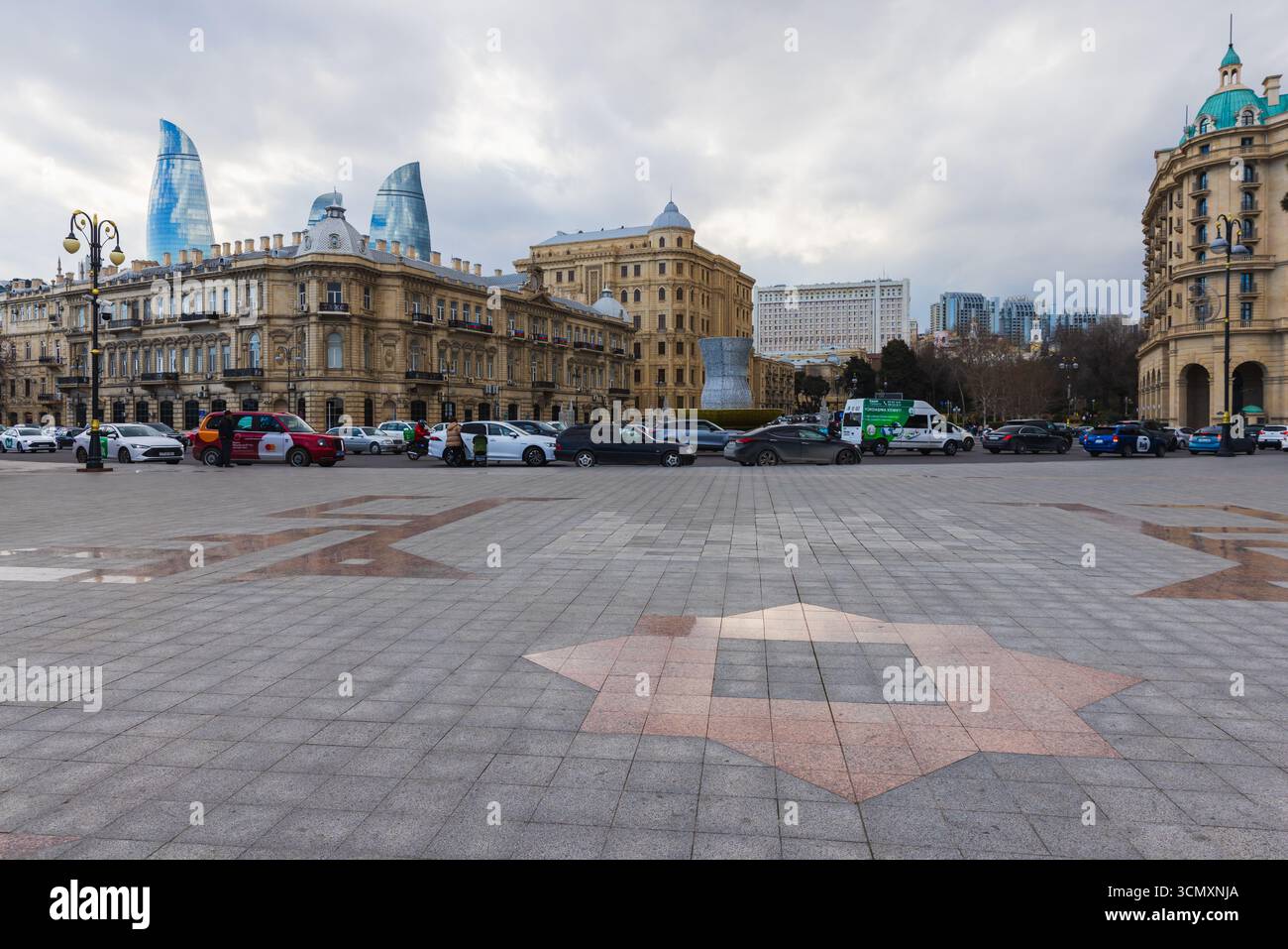 Bakou, Azerbaïdjan - 23 mars 2025 : vue de la place Azneft par temps nuageux, les gens marchent dans la rue. Un paysage urbain mêlant architecture historique et moder Banque D'Images