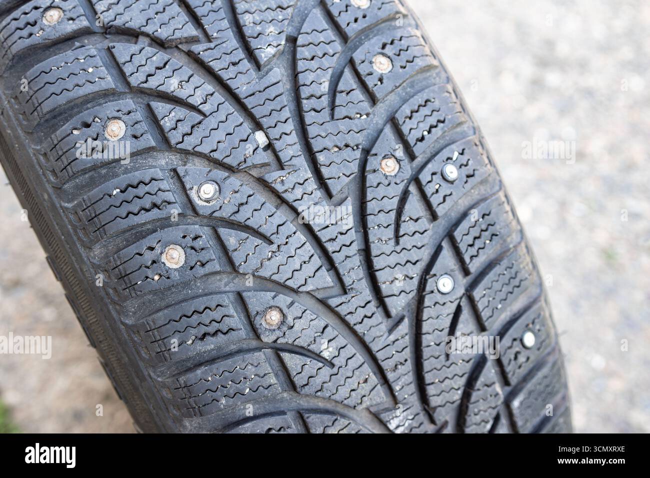 Des goujons usés indiquent une utilisation prolongée sur des surfaces verglacées, le remplacement améliore la traction et la sécurité. avec un accent sélectif sur la bande de roulement des pneus Banque D'Images