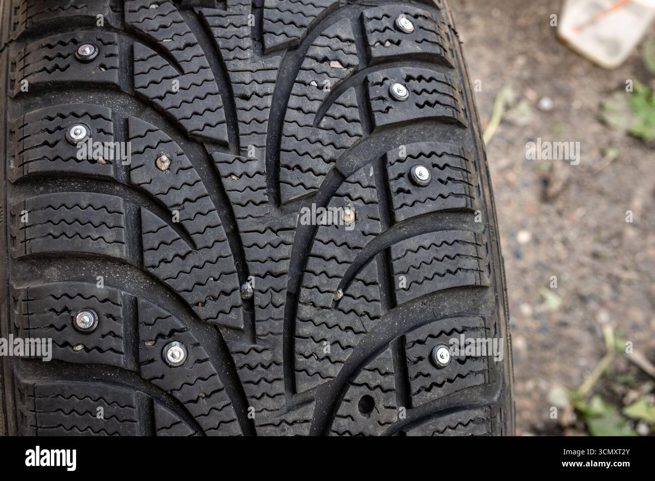 un trou de goujon vide dans un pneu d'hiver indique une défaillance mécanique ou des dommages causés par un impact, ce qui réduit la traction et augmente le risque d'usure au fil du temps avec le sel Banque D'Images